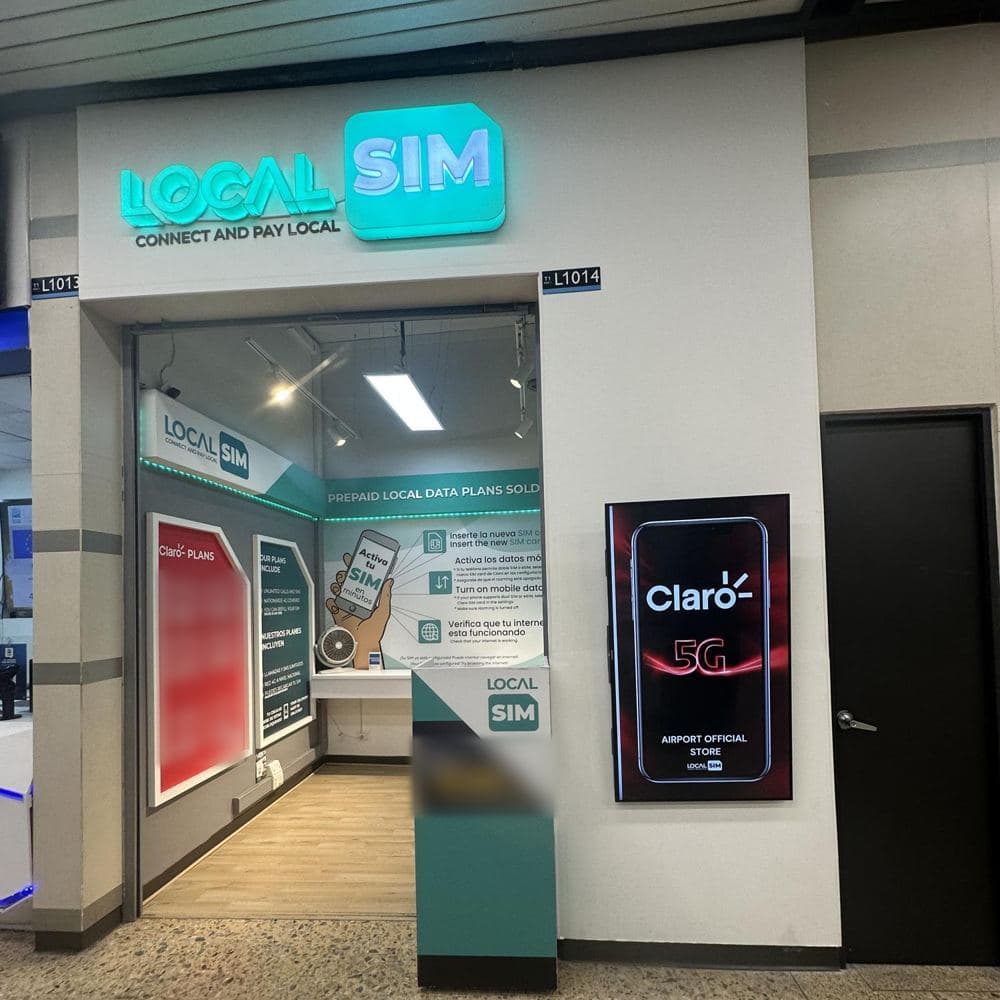 Front of the Local SIM store, Local 1014, with its green illuminated sign.